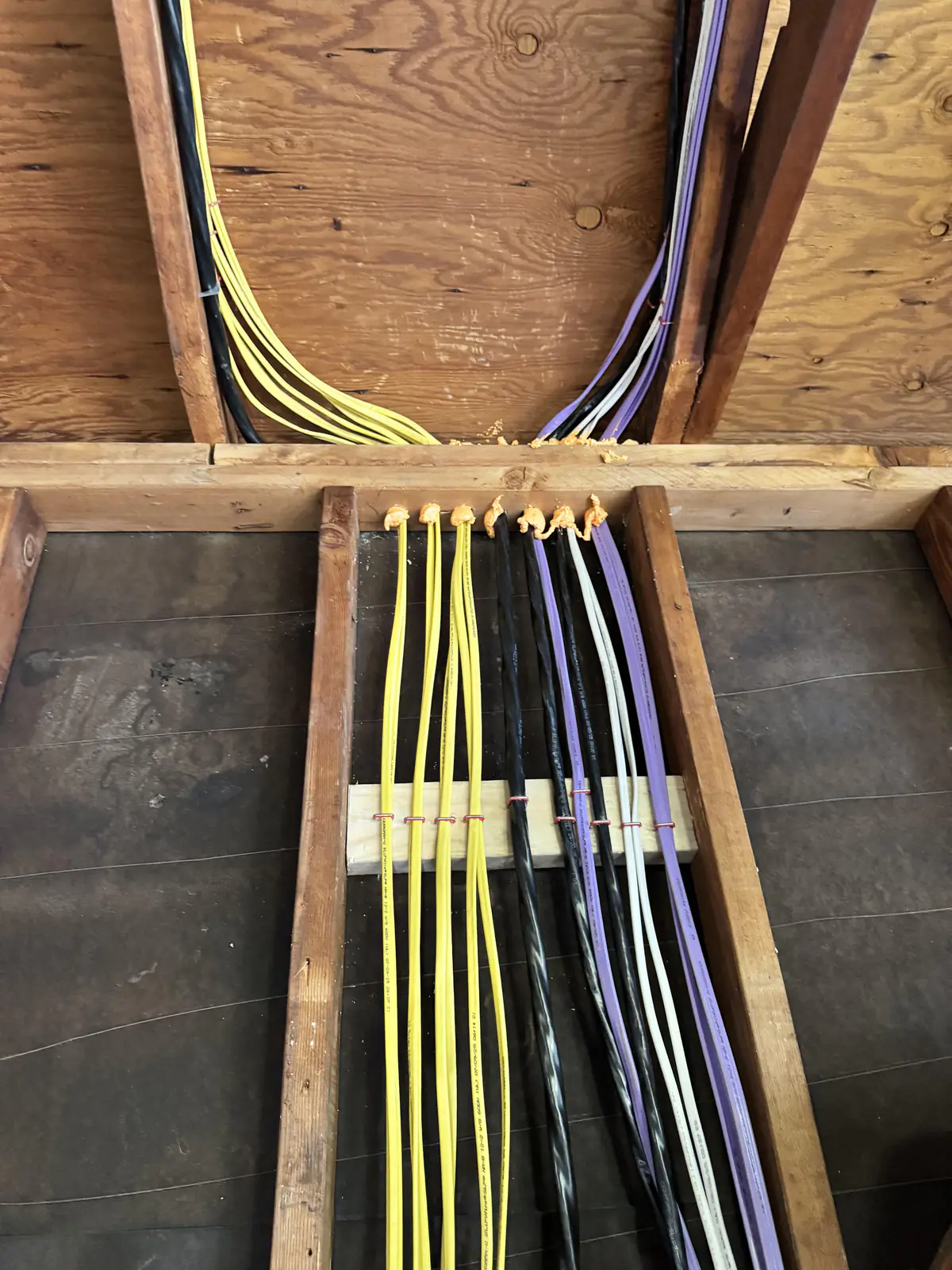 Neatly secured electrical cables running through exposed wall and ceiling framing